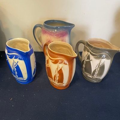 Plusieurs vases de différentes couleurs sont alignés sur une table