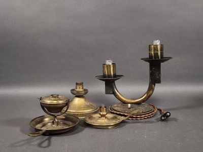 three brass candles and a candle holder on a grey background