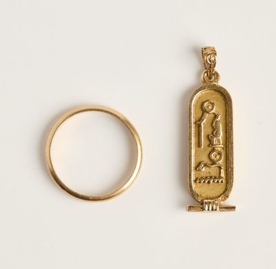 une image représentant une bague en or et un hiéroglyphe égyptien sur un fond blanc