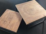 two tables with wooden tops and metal legs on a black surface