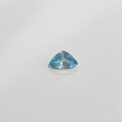 a blue topaze trillion cut diamond on a white surface
