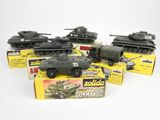 six véhicules militaires miniatures sont alignés en rang sur une surface blanche