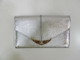 clutch bag made of silver snakeskin with a gold butterfly on the front