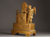 a gold clock with an angel on top of it