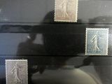 three stamps on a black surface with a shadow of a person