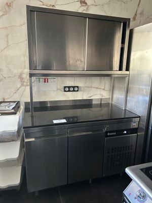 une cuisine en acier inoxydable équipée d'un réfrigérateur et d'une cuisinière