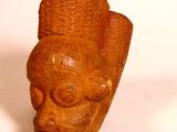 a brown sculpture of a head on a white surface