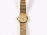 a gold watch on a white surface with a white background