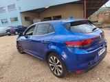 the rear end of a blue car parked in front of a building