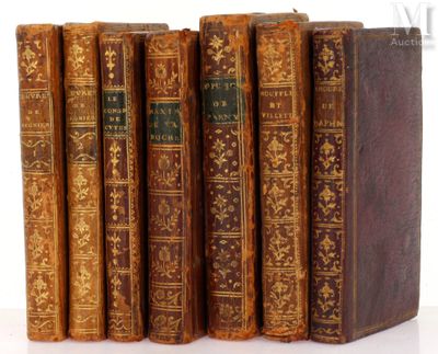 six vieux livres sont alignés sur une surface blanche