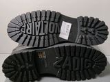 the soles of a pair of black boots on a white surface