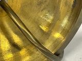 a gold plate with a metal handle on a table