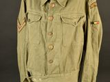 a green jacket on a mannequin stand with a black background