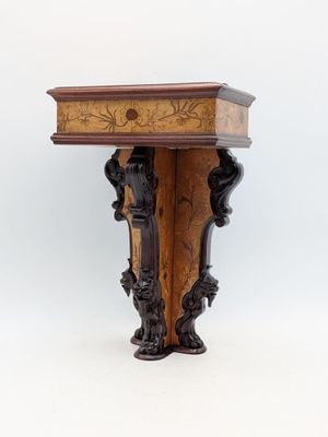 a small wooden table with carvings on it