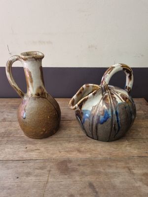 two vases that are sitting on a wooden table