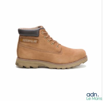 un gros plan sur une paire de bottes marron sur fond blanc