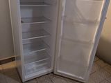 a white refrigerator with its door open in a kitchen