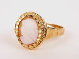 a close up of a gold ring with a pink stone in the center