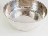 a silver bowl sitting on a white table