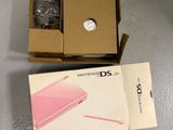 packaging of a pink nintendo ds game console sitting on top of a table