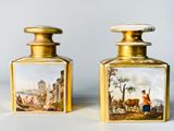 pair of gold - plated glass bottles with paintings of people and animals on them