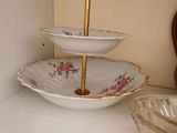 a shelf with three plates and a bowl on top of it