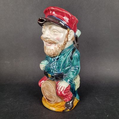 a figurine of a man sitting on a stool