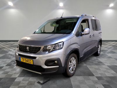 La camionnette argentée est garée sur un sol en carrelage à damier.