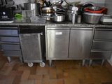 Il y a beaucoup de casseroles et de poêles sur le plan de travail de cette cuisine