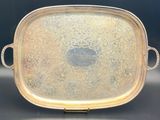 an antique silver plate with handles and handles on a black surface
