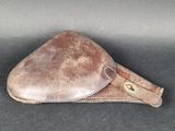 étui en cuir marron avec des finitions en laiton sur un fond noir