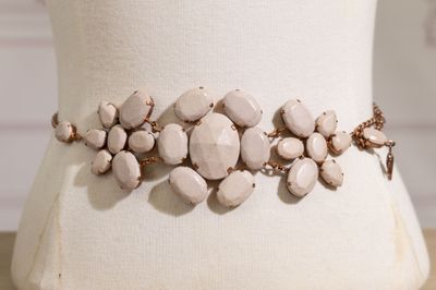 un gros plan d'un bracelet orné de pierres blanches, porté par un mannequin