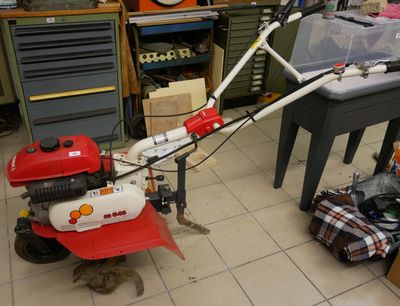 une tondeuse à gazon rouge et blanche posée par terre