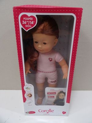 barbie doll with red hair and pink outfit in pink box