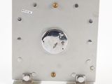 a silver clock on a metal stand on a white surface