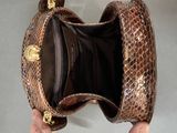 a person holding a snake skin purse in their hand