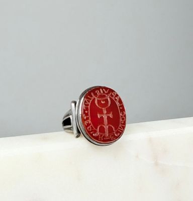 une image représentant une bague rouge posée sur un comptoir blanc