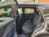 a car that has its door open and the back seat down