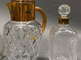 un pichet en verre et une bouteille en verre posés l'un à côté de l'autre