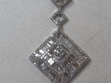 a close up of a diamond pendant on a white surface