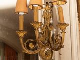 a gold chandelier hanging from a mirror in a room