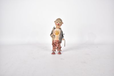 une figurine représentant un clown tenant un ours en peluche