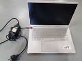 a white laptop computer sitting on a table with a charger