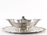 un plateau ancien en argent sur lequel sont posés un bol et une soucoupe