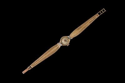 une image représentant une montre en or sur fond noir