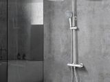 a close up of a shower head with a hand shower in a bathroom