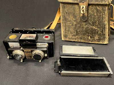 deux vieux appareils photo et un sac posés sur une table
