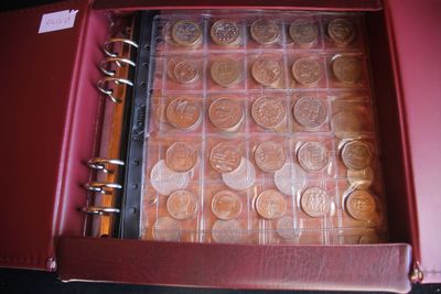 a red case with a bunch of coins inside of it