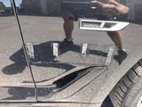 a reflection of a man standing in the reflection of a car