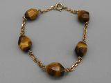 un bracelet composé de perles « œil-de-tigre » et d'une chaîne en or